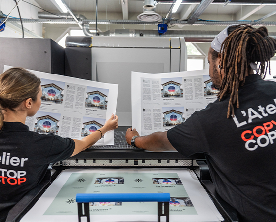Deux personnes tenant des impressions dans un atelier Copytop